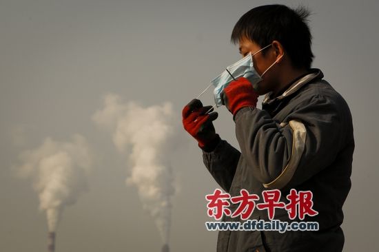 2013年12月13日,一名外来务工者因无法忍受南京八卦洲岛上的刺鼻气味而戴上口罩工作。早报记者