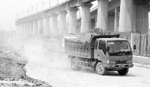 双麒路上，倾倒垃圾的车辆驶过，扬尘弥漫