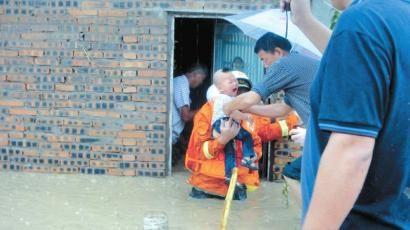 洪水中,小孩被吓得嚎啕大哭。王华逸 摄