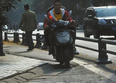 沿着中同仁路往西走,宽约2米的自行车道不断变窄,最终在距离槐树街交汇口5米处出现一个“瓶颈”。“瓶颈”处,实线与人行道的距离不足 20厘米。